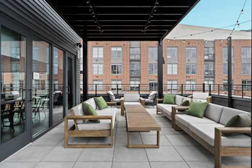 A patio with a table and chairs is surrounded by a brick building.