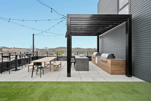 A patio area with a table and chairs under a pergola.
