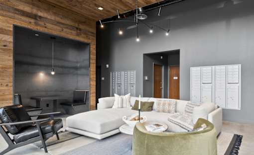 A modern living room with a white couch and a green armchair.