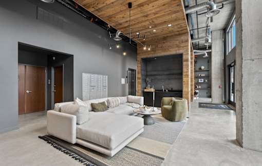 A modern living room with a white sofa and a wooden ceiling.
