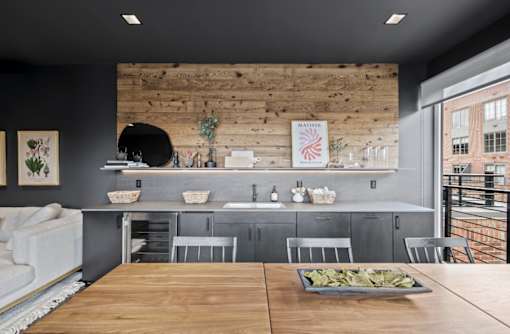 a kitchen with a wooden wall and a table with chairs at The Audubon New Haven, New Haven, Connecticut