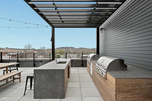 A modern outdoor kitchen area with a grill and seating area.