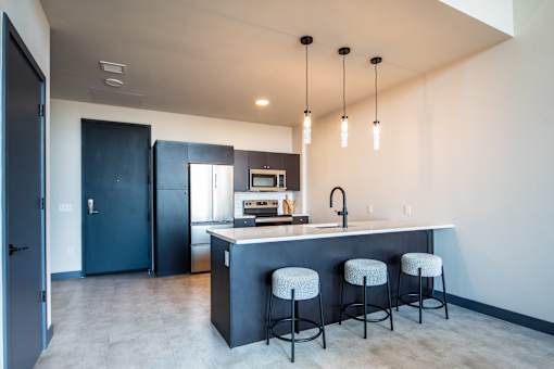 A kitchen with a bar stool and a kitchen island. at The 55 Elm Club, Hartford