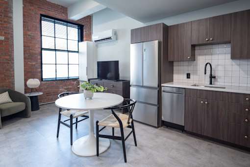 A kitchen with a table and chairs in front of a refrigerator. at The 55 Elm Club, Hartford, CT, 06106