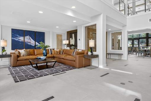 A modern living room with a large couch and a painting on the wall.