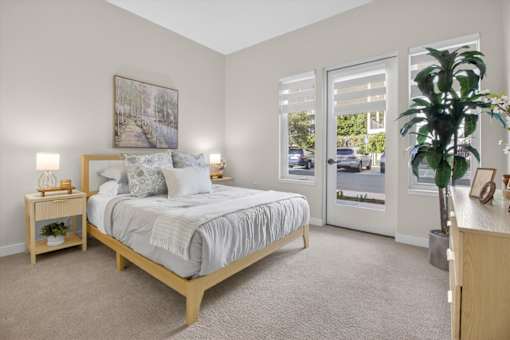 A bedroom with a large bed and a painting on the wall.