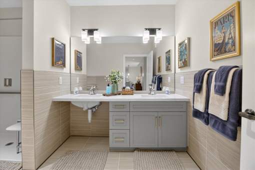 A bathroom with a sink, mirror, and towel rack.