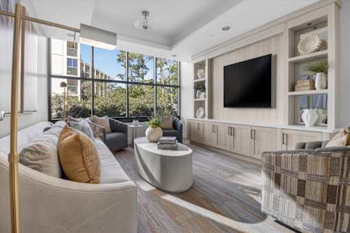 A modern living room with a large flat screen TV mounted on the wall.