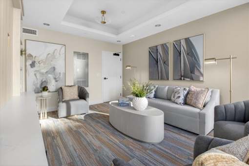 A modern living room with a grey sofa and a wooden floor.