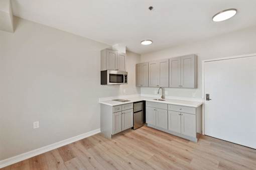 A kitchen with a microwave, sink, and cabinets.
