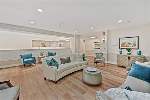 A living room with a white couch and blue pillows.