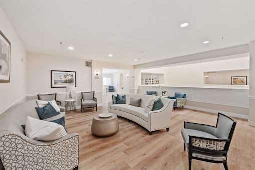 A living room with a white couch and a black and white patterned chair.