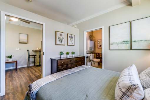 A bedroom with a large bed and a chair.