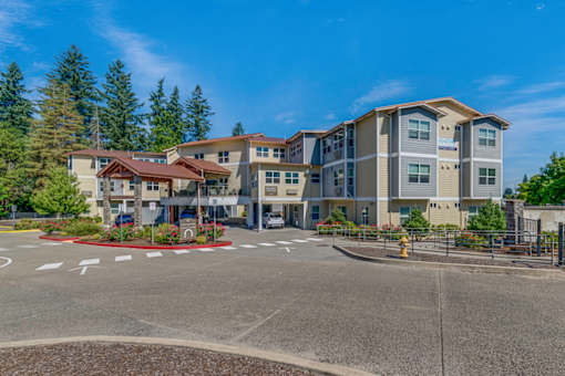 A large apartment complex with a parking lot in front.
