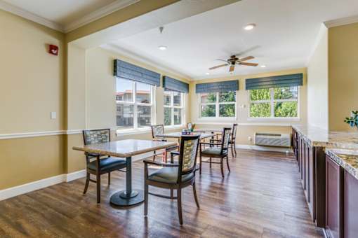 A dining room with a table and chairs.