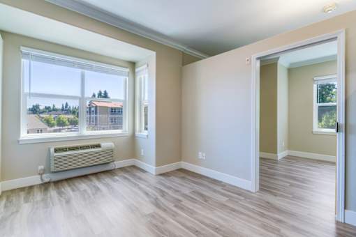 A room with a window and a radiator on the floor.