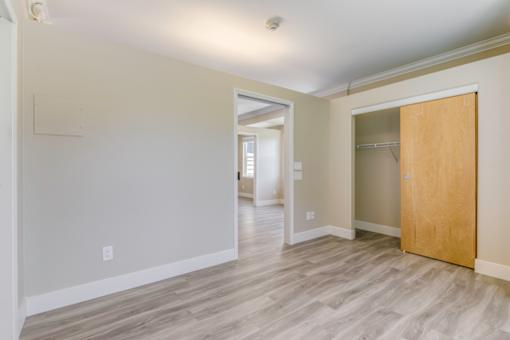 A room with a wooden floor and a door on the right side.