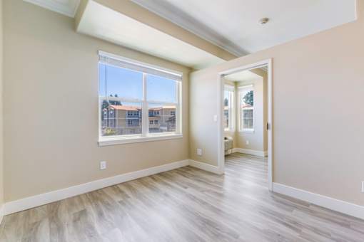 A room with a large window and a view of a building across the street.