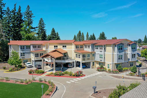 A large apartment complex with a parking lot in front.