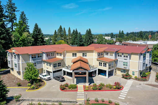 A large apartment complex with a parking lot in front.