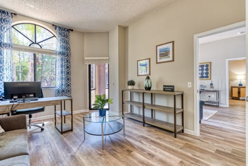 the living room of a home with a desk and a window