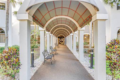 A long walkway with a white arched ceiling and benches on either side.