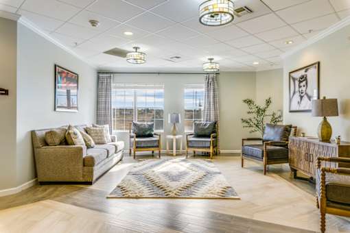 A well-lit living room with a grey sofa, a wooden coffee table, and a rug on the floor.
