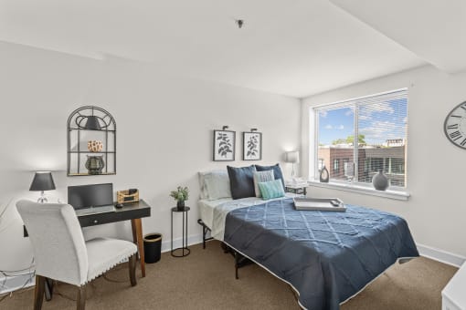 a bedroom with a bed and a desk and a window