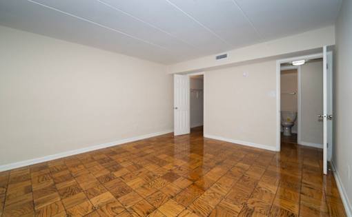 A room with wooden flooring and white walls.