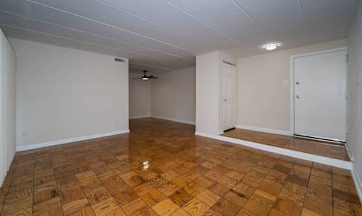 A room with wooden flooring and white walls.