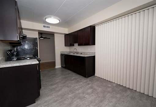 A kitchen with dark brown cabinets and a white countertop.