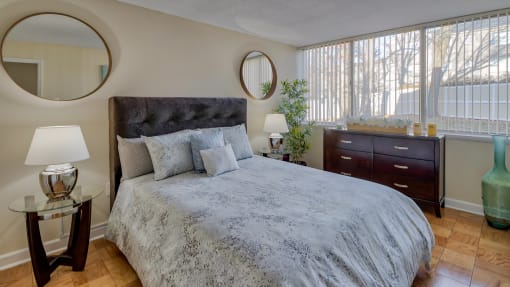 a bedroom with a large bed and two windows