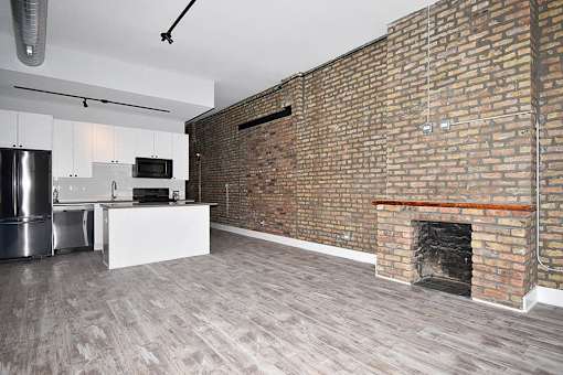 A room with a brick wall and a fireplace.