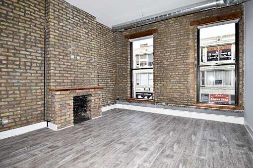A room with a brick wall and a fireplace.