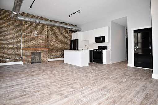 A room with a brick wall and wooden flooring.