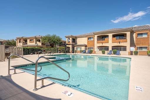 A swimming pool with a diving board in front of a building.