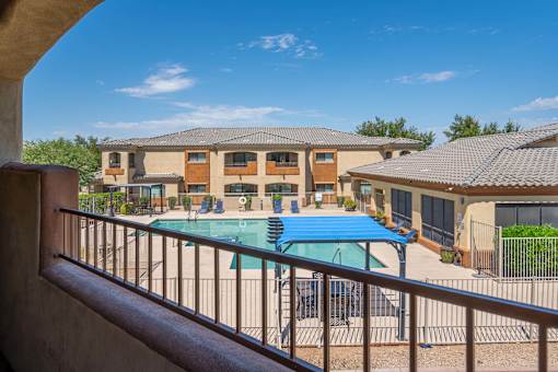 A pool in a courtyard surrounded by houses.