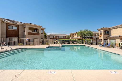 A large swimming pool in front of apartment buildings.