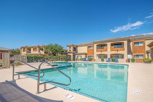 A swimming pool with a diving board in front of a building.