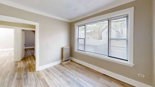 A room with a window and a radiator on the wall.
