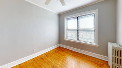 A room with a window and a fan on the ceiling.