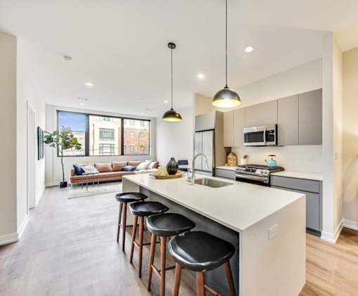 an open kitchen and living room with an island and bar stools