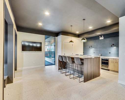 a large kitchen with a bar and a tv