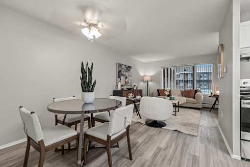 A well-lit, modern dining room with a table set for four.