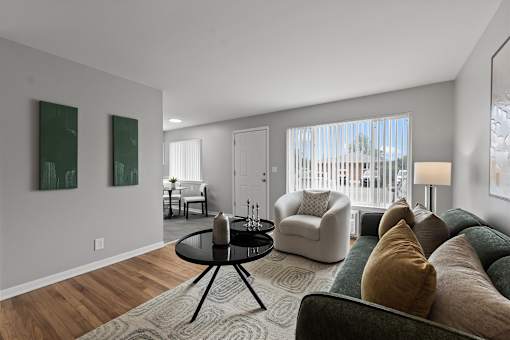A living room with a black table and a green couch.