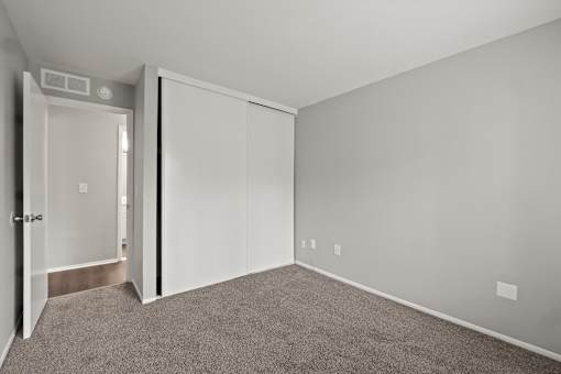A room with a carpeted floor and a white door.