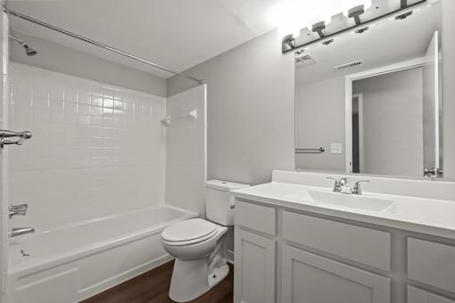 A white bathroom with a toilet, sink, and bathtub.