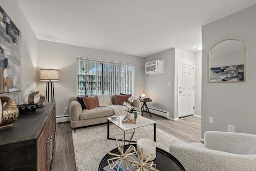 A living room with a couch, a coffee table, and a large mirror.