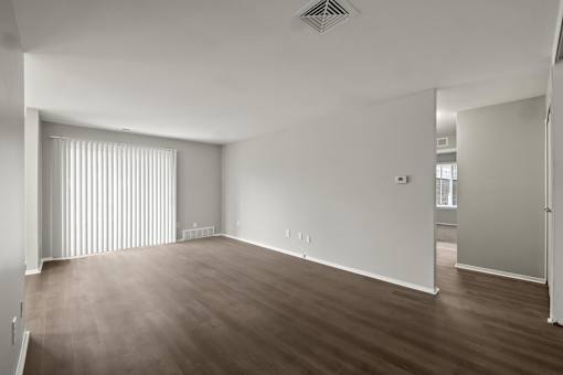 A large empty room with wooden floors and white walls.