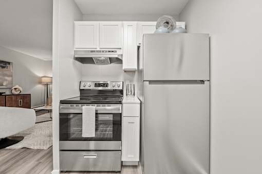 A modern kitchen with a stainless steel oven and white fridge.